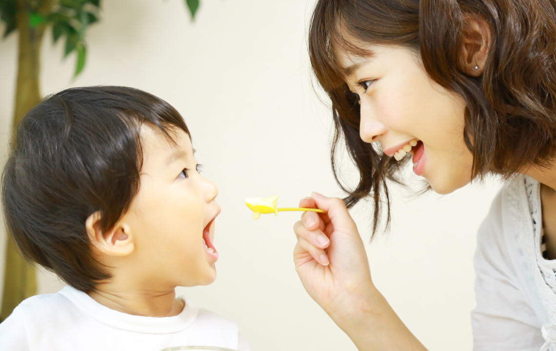 小さな子どもに薬を飲ませている様子